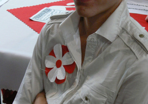 Uczennica z kokardą narodową przyczepioną do bluzki